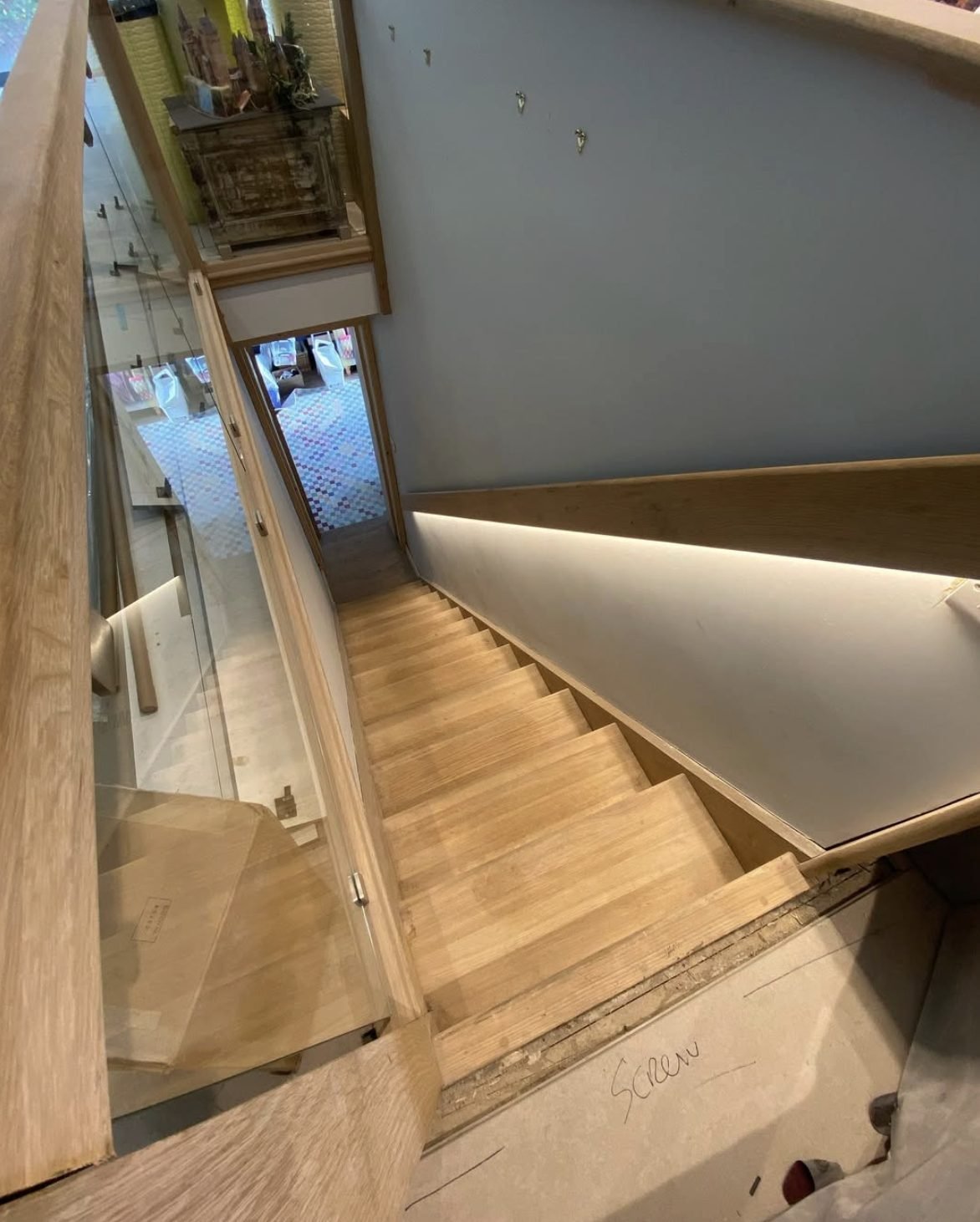 Concealed LED strip lighting fitted beneath a stair handrail